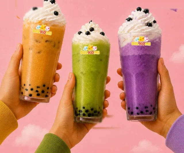 Three Dalkomi milkshakes with boba held up together